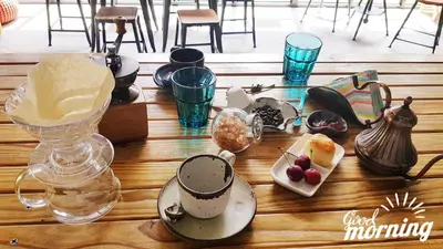 a wooden table topped with cups and a vase with food at The Simple Koh Yao Noi in Ko Yao Noi