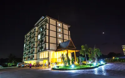 a large building with a clock on it at night at Airport Resort Phuket in Nai Yang Beach
