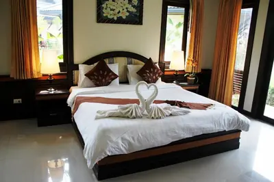 a bedroom with a bed with a swan decoration on it at Airport Resort Phuket in Nai Yang Beach