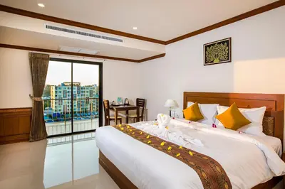 a bedroom with a large bed and a balcony at Airport Resort Phuket in Nai Yang Beach