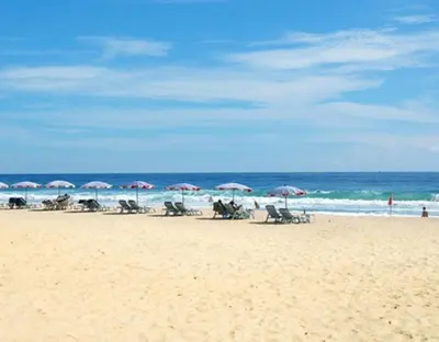 a beach with chairs and umbrellas and the ocean at Karon Princess Hotel SHA EXTRA Plus in Karon Beach