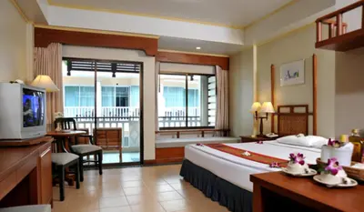 a hotel room with a large bed and a balcony at Karon Princess Hotel SHA EXTRA Plus in Karon Beach