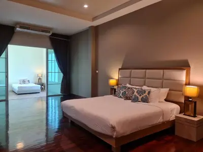 a bedroom with a large bed with two lamps at Villa Kanwara in Ao Nang Beach