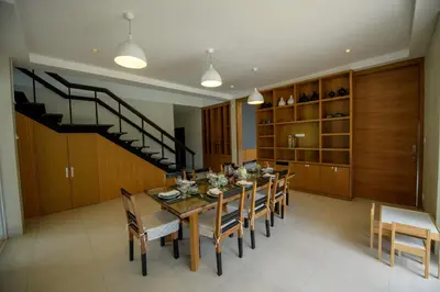 a dining room with a table and chairs and a staircase at Villa Kanwara in Ao Nang Beach