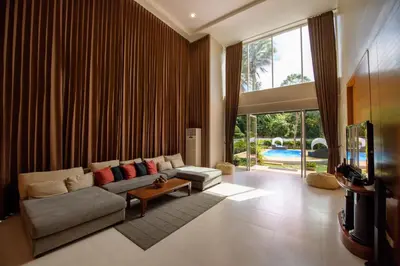 a living room with a couch and a tv at Villa Kanwara in Ao Nang Beach