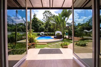 a view of a house with a pool through a glass door at Villa Kanwara in Ao Nang Beach