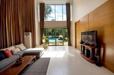 a living room with a couch and a flat screen tv at Villa Kanwara in Ao Nang Beach
