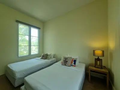 two beds in a room with a window at Villa Kanwara in Ao Nang Beach