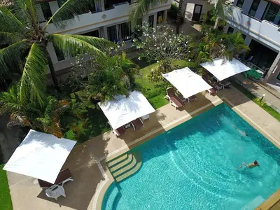an overhead view of a swimming pool with chairs and umbrellas at Babylon Pool Villas in Nai Harn Beach