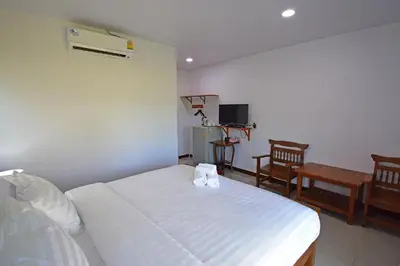 a bedroom with a white bed and a chair at Anissa Resort Koh Yao Yai in Ko Yao Yai