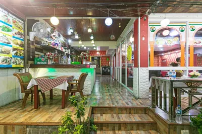 a restaurant with a table and chairs in a room at Sea Beach Paradise in Patong Beach