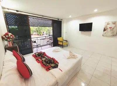 a bedroom with a large white bed and a balcony at Sea Beach Paradise in Patong Beach