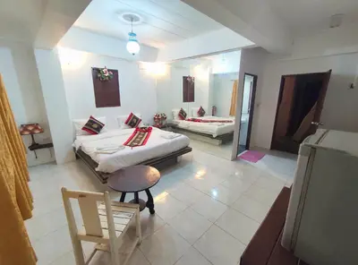 a room with two beds and a chair in it at Sea Beach Paradise in Patong Beach