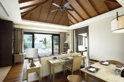 a living room with a couch and a table at Trisara Villas & Residences Phuket in Nai Thon Beach