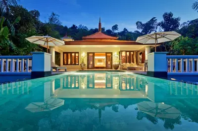 a villa with a swimming pool at night at Trisara Villas & Residences Phuket in Nai Thon Beach