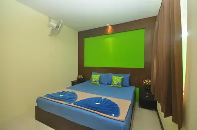 a bedroom with a green screen above a bed at Pak Klong Room for rent in Phi Phi Don