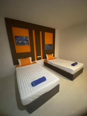 two beds with orange and blue pillows in a room at Pak Klong Room for rent in Phi Phi Don