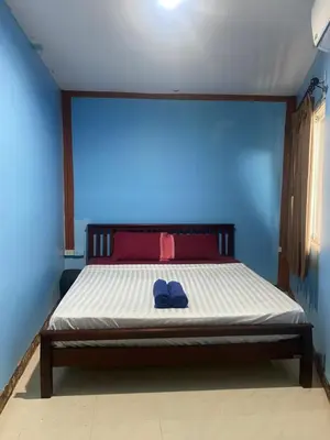 a bedroom with a bed with a blue wall at Pak Klong Room for rent in Phi Phi Don