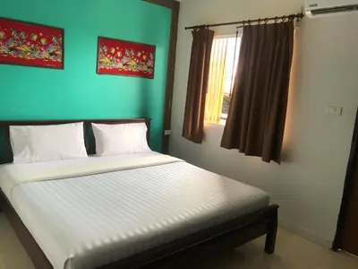 a bed in a bedroom with a green wall at Pak Klong Room for rent in Phi Phi Don