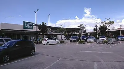 a parking lot with cars parked in front of a store at Studio with aircon n kitchen in Bang Tao Beach