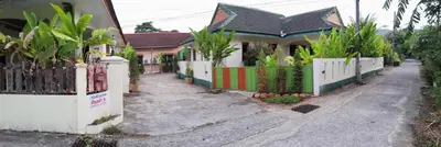 a house with a white fence in front of it at Studio with aircon n kitchen in Bang Tao Beach