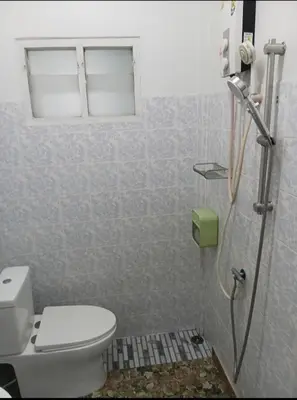 a bathroom with a toilet and a window at Studio with aircon n kitchen in Bang Tao Beach