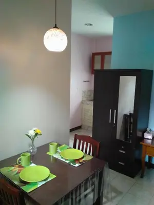 a dining room table with two green plates on it at Studio with aircon n kitchen in Bang Tao Beach