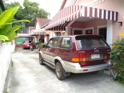a red car parked in front of a house at Soi Bang thao 2 Aircon Studio in Bang Tao Beach