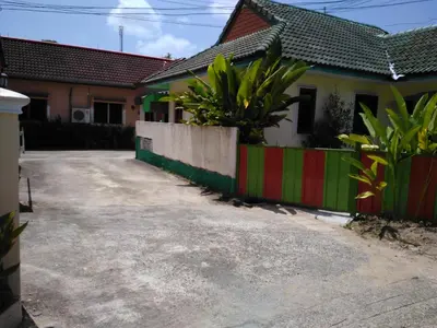 a house with a colorful fence next to a driveway at Soi Bang thao 2 Aircon Studio in Bang Tao Beach