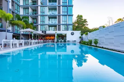 a swimming pool in front of a building at Oceanstone by Holy Cow, 2-BR, 90 m2, pool view in Bang Tao Beach