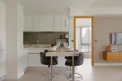 a kitchen with a table and two black chairs at Oceanstone by Holy Cow, 2-BR, 90 m2, pool view in Bang Tao Beach