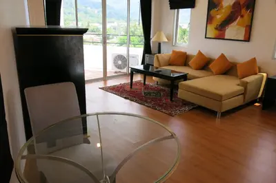 a living room with a couch and a glass table at Orchid Kathu Heights Service Apartments in Kathu