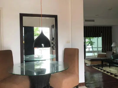 a dining room with a glass table and chairs at Orchid Kathu Heights Service Apartments in Kathu