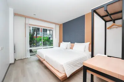 a bedroom with a large bed and a window at The One Cozy, Phuket in Chalong