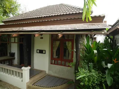 a small house with a porch and a door at Bangtao Beach Chalet Resort in Bang Tao Beach