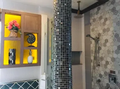 a bathroom with a black and white tiled shower at Bangtao Beach Chalet Resort in Bang Tao Beach