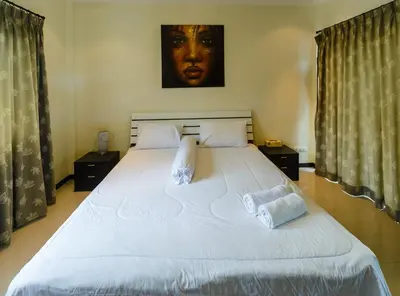 a bedroom with a large white bed with two pillows at Villa With Pool in Bang Tao Beach