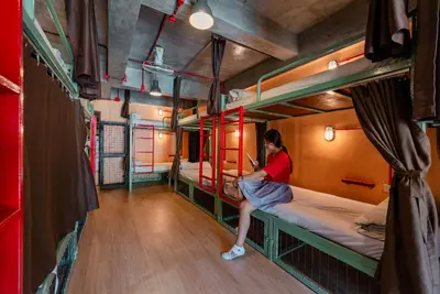 a woman sitting on a bunk bed in a room at Sleeper Hostel in Ao Nang Beach