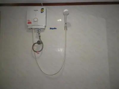 a shower in a bathroom with a hose on a wall at Natacha Hotel in Phi Phi Don