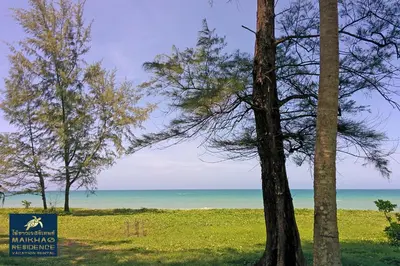 a sign for a beach with trees and the ocean at MaiKhao Residence in Mai Khao Beach