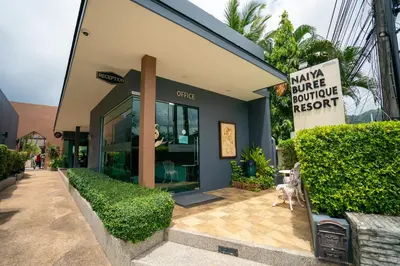 a building with a sign on the side of it at Naiya Buree Boutique Resort Nai Harn Beach in Rawai Beach