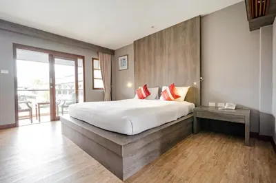 a bedroom with a large bed and a balcony at Naiya Buree Boutique Resort Nai Harn Beach in Rawai Beach