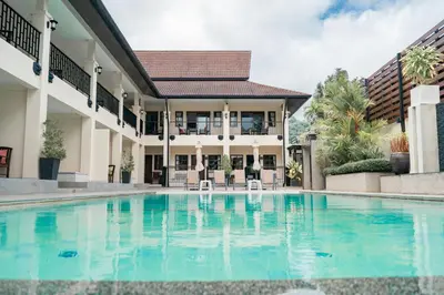 a swimming pool in front of a house at Naiya Buree Boutique Resort Nai Harn Beach in Rawai Beach