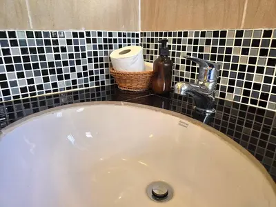 a bathroom sink with a faucet and a roll of toilet paper at Krabi Green Hill Pool Villas in Ban Nong Thale