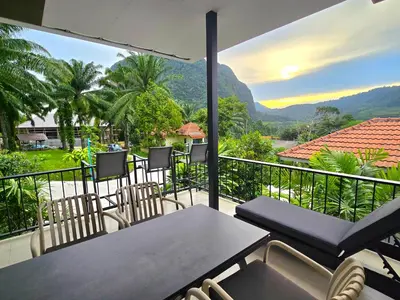 a balcony with a table and chairs and mountains at Krabi Green Hill Pool Villas in Ban Nong Thale