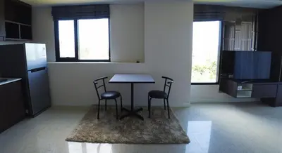 a kitchen with a table and two chairs on a rug at 1-BR Sea View, Aristo condo, Surin Beach in Surin Beach
