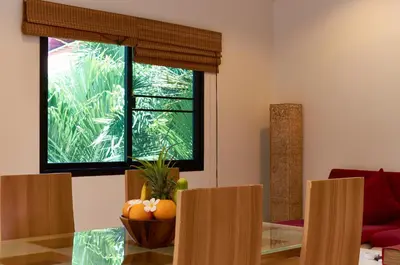 a living room with a table and a window at Phuket Riviera Villas Hotel in Nai Harn Beach