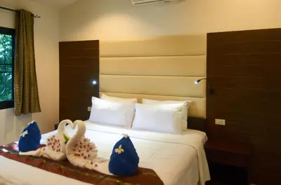 a bedroom with a bed with swans decorations on it at Phuket Riviera Villas Hotel in Nai Harn Beach