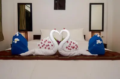 two swans are made to look like hearts on a bed at Phuket Riviera Villas Hotel in Nai Harn Beach