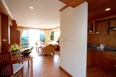 a kitchen and living room with a table and chairs at Sun Hill Hotel Patong in Patong Beach